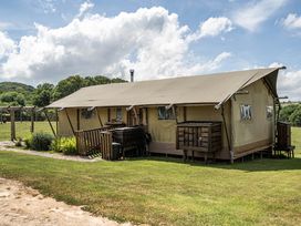 A tent with wooden platform and outdoor seating at Luxury Safari Lodge Sleeps 4/6 Deer Park Dogs Ok Zeal Monachorum near Bow