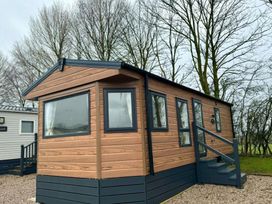 A mobile home with steps surrounded by trees at a campsite