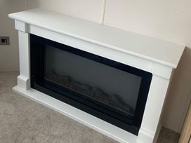 A fireplace with a white mantle in a living room