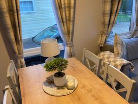 A dining area with a table and lamp at the property location