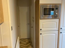 A kitchen with cabinets and a microwave at The Old Barn in Manchester