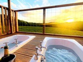 Two bathtubs on a wooden deck with a scenic view at a property
