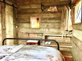 A bedroom with a bed and wooden shelves at The Old Barn in Manchester