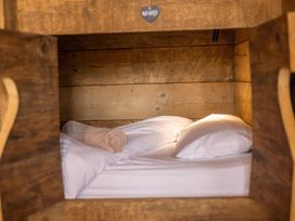 A bed with pillows and a blanket in a wooden structure