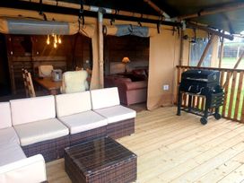An outdoor seating area with a sofa, coffee table, dining table, and grill at a property