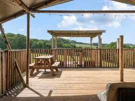 A deck with a wooden table and benches overlooking a landscape at Luxury Safari Lodge Sleeps 4/6 Deer Park Dogs Ok Zeal Monachorum near Bow