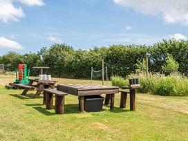 A picnic area with a wooden table and benches at Luxury Safari Lodge Sleeps 4/6 Deer Park Dogs Ok Zeal Monachorum near Bow