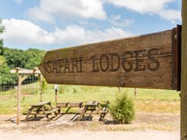 A sign pointing to Safari Lodges with picnic tables at Luxury Safari Lodge Sleeps 4/6 Deer Park Dogs Ok Zeal Monachorum near Bow