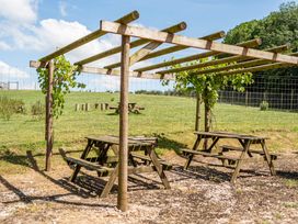 An outdoor area with picnic tables under a pergola at Luxury Safari Lodge Sleeps 4/6 Deer Park Dogs Ok Zeal Monachorum near Bow