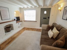 A living room with a couch and television at Pax Cottage