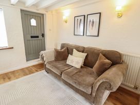 A living room with a sofa and a door at Pax Cottage