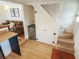 A living room with a sofa and staircase at Pax Cottage