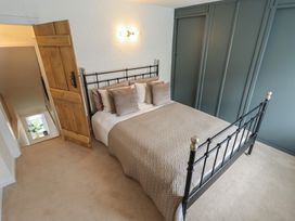 A bedroom with a bed and a wooden door at Pax Cottage
