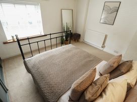 A bedroom with a bed, pillows, and a window at Pax Cottage