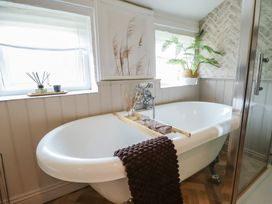A bathtub with a towel and decorative items at Pax Cottage