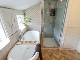 A bathroom with a bathtub and shower in Pax Cottage