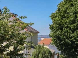 A view of houses and trees with sea in the background at 3 Heath Park Brixham