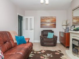 A living room with a sofa and armchair at 3 Heath Park in Brixham