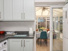 A kitchen with countertop and appliances leading to a dining area at 3 Heath Park Brixham