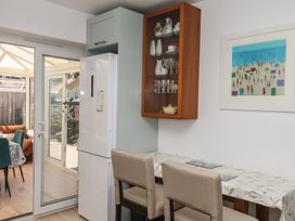 A kitchen featuring a refrigerator, table and bar stools at 3 Heath Park Brixham