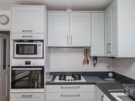 A kitchen with cabinets, microwave, oven, and stove at 3 Heath Park in Brixham