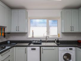 A kitchen with cabinets, sink, dishwasher, and window at 3 Heath Park Brixham