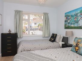 A bedroom with two beds and a window at 3 Heath Park in Brixham