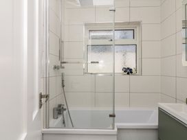 A bathroom with a bathtub and shower at 3 Heath Park, Brixham