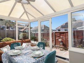 A conservatory with a table and chairs at 3 Heath Park in Brixham