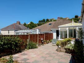A garden with a conservatory and patio at 3 Heath Park in Brixham