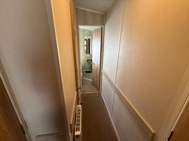 A hallway with doors and a radiator at Haggerston Castle Lakeside East 76, Berwick-upon-Tweed