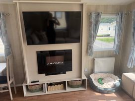 A living room with television and seating area at Haggerston Castle Lakeside East 76 in Berwick-upon-Tweed