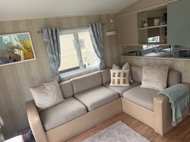 A living room with a couch and window at Haggerston Castle Lakeside East 76 in Berwick-upon-Tweed