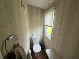 A bathroom with a toilet and a towel holder at Haggerston Castle Lakeside East 76 Berwick-upon-Tweed