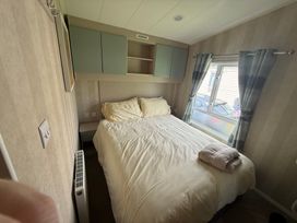 A bedroom with a bed and window at Haggerston Castle Lakeside East 76 Berwick-upon-Tweed
