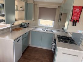 A kitchen with a sink and gas stove at Haggerston Castle Lakeside East 76 Berwick-upon-Tweed
