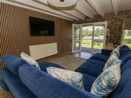 A living room with a sofa and television at The Cart House in Pontsian