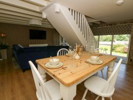 A dining room with a wooden table and chairs at The Cart House in Pontsian