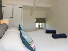 A bedroom with a bed and wardrobe at The Cart House in Pontsian