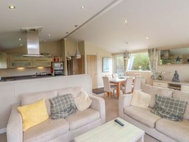 A living room with sofas and a dining area at 56 The Stables in Pwllheli