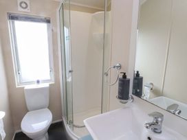 A bathroom with a shower, toilet, and sink at 56 The Stables Pwllheli