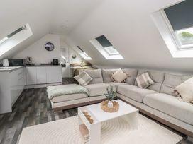 A living room with a sofa and kitchen area at Fields view in Bridlington