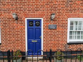 A blue door with a nameplate at Cobblers Cottage in Southwold
