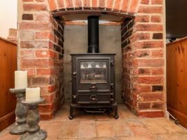A stove with candles in a living room at Cobblers Cottage Southwold