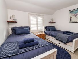 A bedroom with twin beds and a window at Cobblers Cottage in Southwold