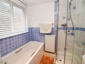 A bathroom with a bathtub and shower at Cobblers Cottage Southwold