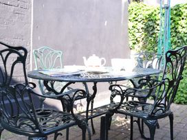 A table with chairs and a teapot at Cobblers Cottage in Southwold