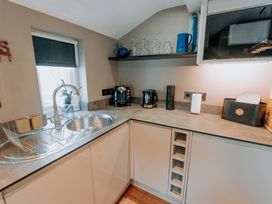 A kitchen with a sink, kettle, coffee machine and dish rack at TyCosy in St Davids