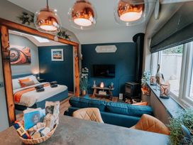 A living room with a bed, sofa, and television at TyCosy in St Davids