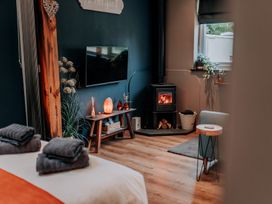 A living room with a television, fireplace, and wooden furniture at TyCosy in St Davids